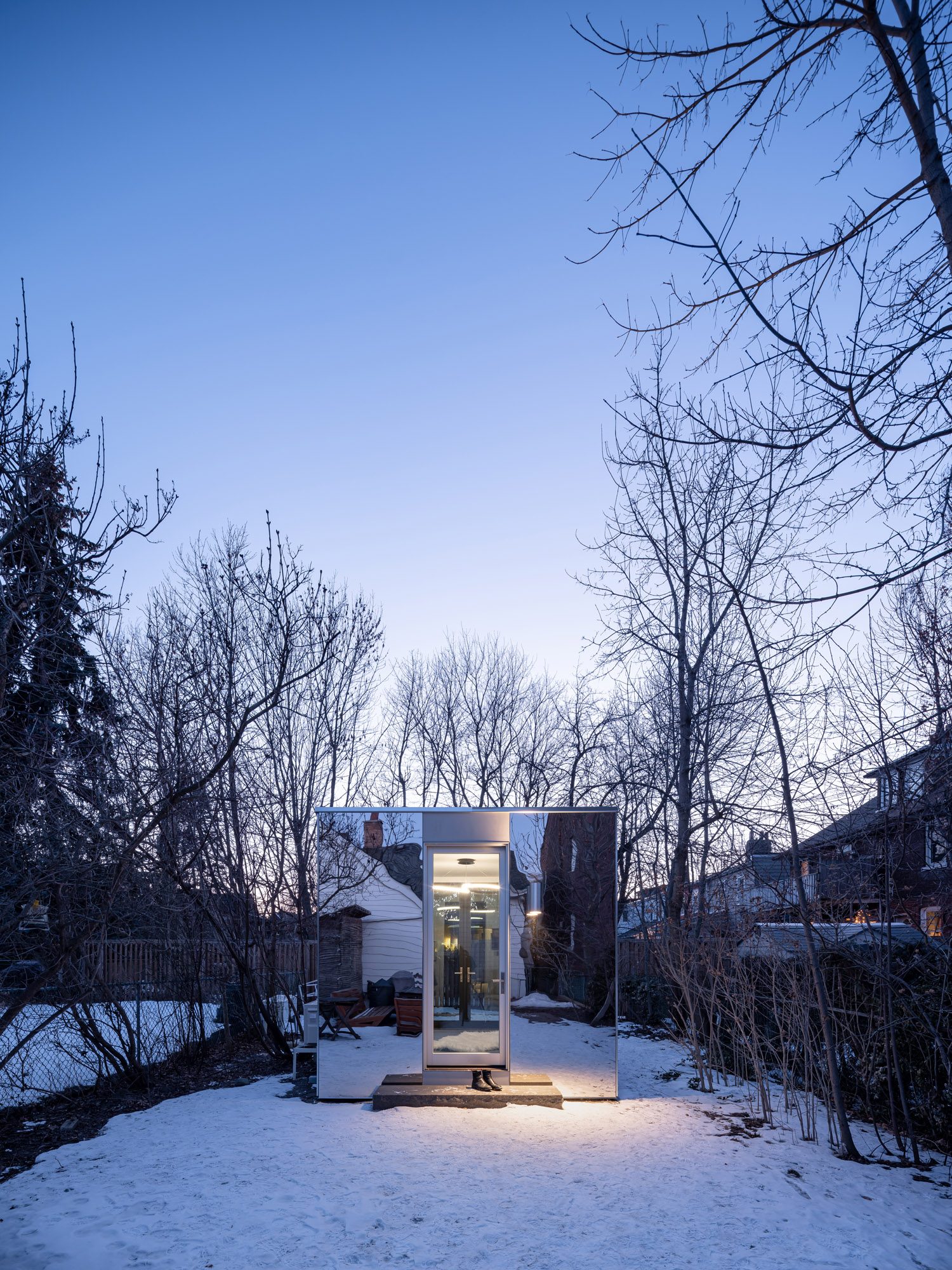 Parkdale Pavilion mirror-clad facade at dusk, Toronto custom home by Doty Construction